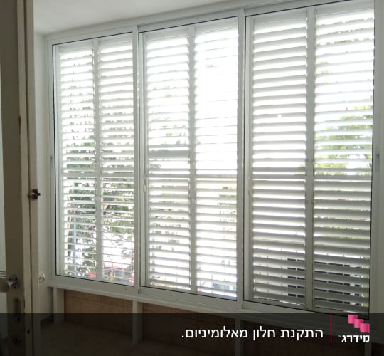 סגירת מרפסת באלומיניום לבן עם חלונות הזזה ותריסים